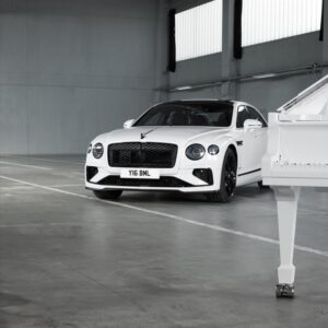 A Distance image of a Bentley at the side of a white Steinway Piano